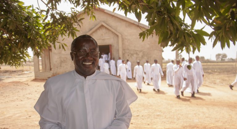 The rector of the Good Shepherd Seminary, Kaduna with students filing out of chapel behind him.