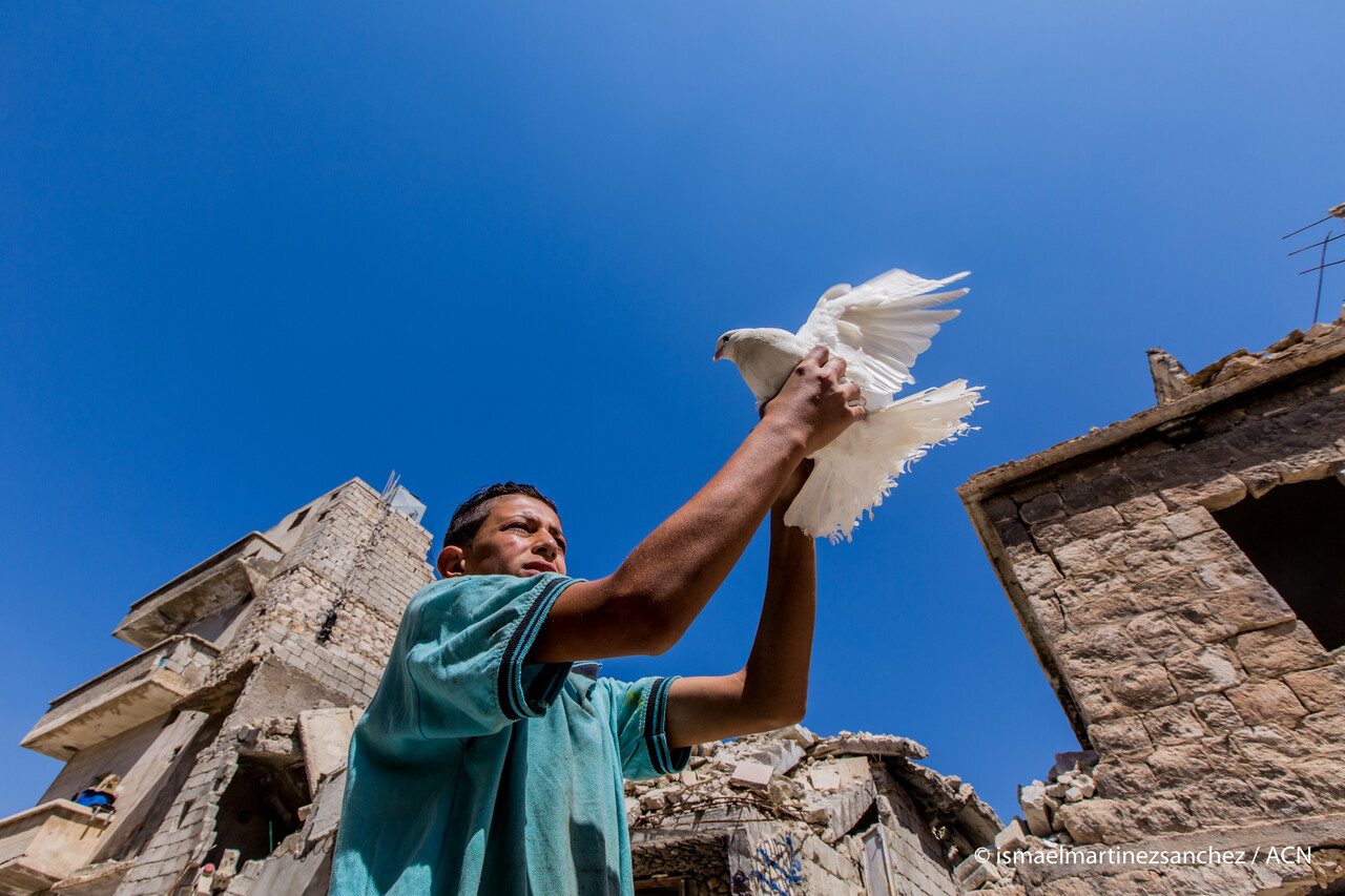 A refugee with a dove in Aleppo. (© Ismael Martínez Sánchez / ACN).