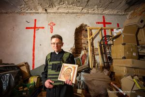 Fr. Maksym, parish priest of the Sacred Heart of Jesus in the city of Kherson, wearing a bulletproof vest, holding an icon of Our Lady.